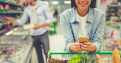 Woman using phone at grocery store