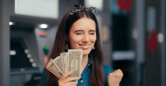 Excited woman holding cash