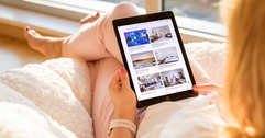 Woman holding iPad with Airbnb listings