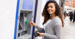 Smiling woman using an ATM