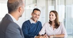 A businessman sitting at a table with two customers.