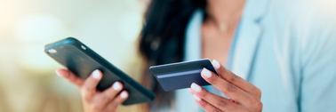 Woman holding a credit card and phone