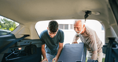 senior helping grandchild load car