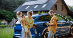 Couple with child in front of a car and house