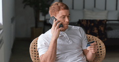 person on phone with credit card