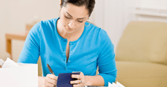 Woman writing in a checkbook