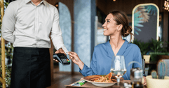 Woman using credit card at restaurant