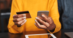 Woman using credit card on cellphone