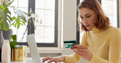 Woman with credit card on laptop