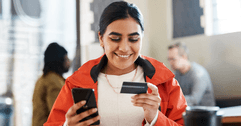 Woman using credit card on phone