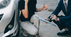Car insurance agent and client assessing damage