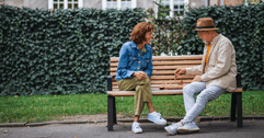 Older couple playing chess on bench