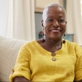 smiling senior woman sitting on sofa at home
