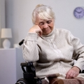 depressed aged lady in wheelchair thinking about health problems at hospital