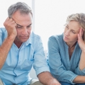 worried couple using their laptop to pay their bills