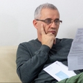 Worried middle-aged man reading unexpected news in paper document
