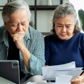 asian senior couple checking and calculate financial billing together