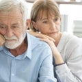 senior couple thinking while sitting on couch