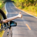 A driver on a two-lane road gives a thumbs up.