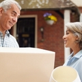mature couple carrying boxes on moving day