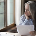 elderly retired woman thinking over paper documents