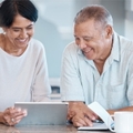 happy asian couple using tablet on countertop 