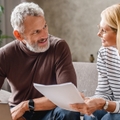middle aged couple with laptop studying documents