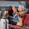old lady is sitting on bench at airport lounge