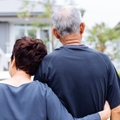 senior couple from behind looking at front of house
