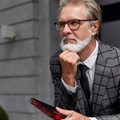 senior business man thinking while holding diary