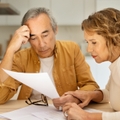 senior spouses sitting at table full of papers