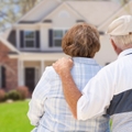 retired couple sitting outside new house