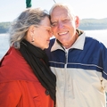 smiling senior couple on sailboat