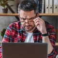confused businessman looking at laptop screen