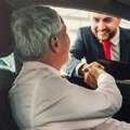 senior man buying car from dealer