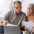 senior couple reading bills at home