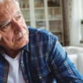 Worried senior man sitting on a sofa