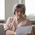 senior female accountant checking paper invoices