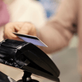 Close up of a senior man paying with credit card on self-service cash register in supermarket