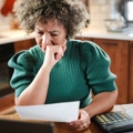 woman reviews paperwork at her kitchen