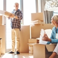 couple packing boxes together in their home