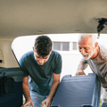 senior helping grandchild load car