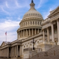 Low angle view of the east entrance to United States Capitol building in Washington DC with marble dome and stairs