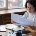 woman sit with laptop and paper document