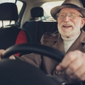 grey-haired man driving car