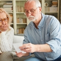 senior couple worried looking at bills