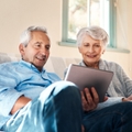 happy senior couple watching on tablet together