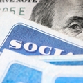 Dollar bill with Benjamin Franklin's eyes looking and Social Security cards