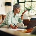 Woman looking confused with laptop and notes