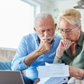 Worried older couple looking at bills